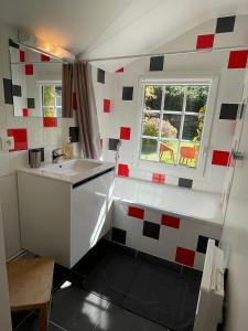 uma pequena cozinha com um lavatório e uma janela em Maison de charme vue sur mer pour 6 pers em Quinéville