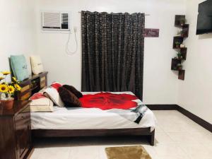 a bedroom with a bed with a red blanket on it at 15pax-U1-Rose&Fer Vigan Transient-Near Calle Crisologo in Bantay