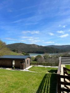 a barn with a view of a lake and mountains at Cabañas O Recuncho do Sor in O Barqueiro