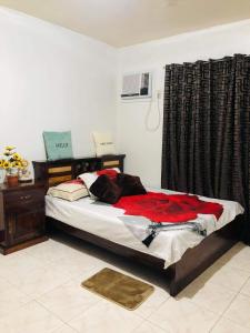 a bedroom with a bed with a red blanket on it at 15pax-U1-Rose&Fer Vigan Transient-Near Calle Crisologo in Bantay