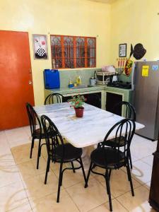 a kitchen with a table with four chairs and a kitchen with auclear at 15pax-U1-Rose&Fer Vigan Transient-Near Calle Crisologo in Bantay