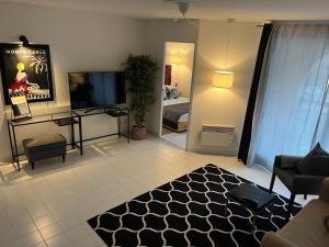 - un salon avec une télévision, un canapé et une table dans l'établissement Monaco Beach Balcony Apartments, à Beausoleil