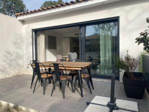 ein Holztisch und Stühle auf einer Terrasse in der Unterkunft Calme Villa Plain-Pied à Bouzigues, Proche Plage et Commerces, 3*** - FR-1-604-45 in Bouzigues