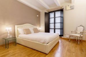 a bedroom with a large white bed and a chair at Martini Castello Boutique Rooms - Historic Center & Cathedral in Cagliari +30 photos
