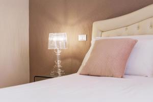 łóżko z poduszką i lampą na stole w obiekcie Martini Rooms Castello w Cagliari