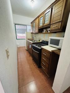 uma cozinha com armários de madeira e um forno com placa de fogão em Departamento Valentina em Santa Cruz Huatulco
