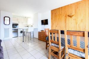 Habitación con cama y cocina con mesa en Appartement 6 pers. à 30m des remontées - Maeva Particuliers - 3 Pièces 6 Personnes Sélection 138716 en L'Alpe-d'Huez