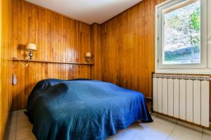 a bedroom with wood paneled walls and a blue bed at Appartement 6 pers. à 30m des remontées - maeva Home - Appartement vue montagne 3 pièces 6 personnes - Sélection MAE-8716 in L'Alpe-d'Huez