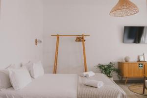 a bedroom with a bed with two towels on it at Pure Fonte Velha B&B in Vila do Bispo