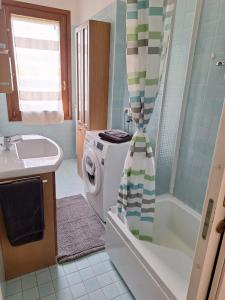 ein Badezimmer mit einer Waschmaschine und einem Waschbecken in der Unterkunft Casa Ida in Scaltenigo
