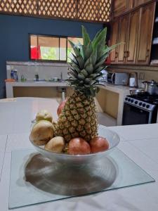 a pineapple in a bowl of fruit on a kitchen counter at VILLA ESMERALDA in Siquirres