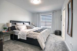 una camera con un grande letto e una finestra di Beautiful 3Bed-with AC-Close to Spruce Meadows & Mountains a Calgary