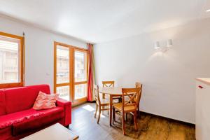 a living room with a red couch and a table at Résidence Les Ravines - maeva Home - Studio 4 Personnes Confort MAE-9397 in Les Allues +12 photos