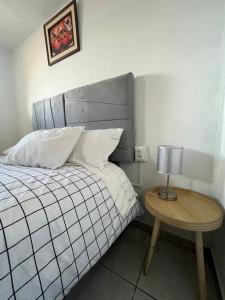 1 dormitorio con 1 cama y 1 mesa con lámpara en Qosqollay Plaza de Armas en Cuzco