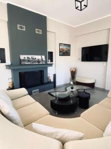 ein Wohnzimmer mit einem Sofa und einem Kamin in der Unterkunft Keskos Luxury Villa in Artemida