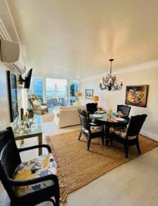a living room with a dining room table and chairs at Wake Up To The Sounds Of The Sea in Freeport