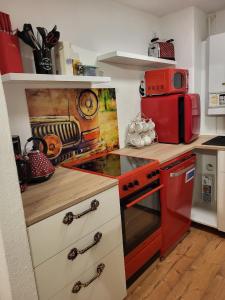 eine Küche mit einem roten Herd und einer Mikrowelle in der Unterkunft Bergblick - b53207 in Königstein an der Elbe