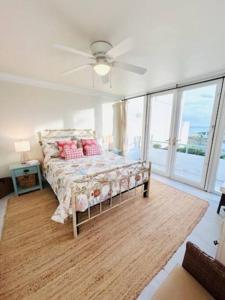 a bedroom with a bed and a ceiling fan at Wake Up To The Sounds Of The Sea in Freeport