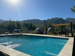 a swimming pool with mountains in the background at Glamping Mendoza in Ciudad Lujan de Cuyo