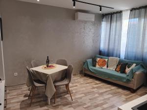 una sala de estar con una mesa y un sofá en Bijoux Apt in the heart of Sofia, en Sofía