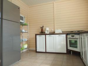 eine Küche mit weißen Schränken und einem Kühlschrank in der Unterkunft Villa diamantine in Le Diamant