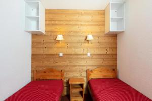 2 letti in una piccola camera con pareti in legno di Les Résidences de Valmorel - maeva Home - 2 Pièces 5 personnes Selection 11 a Valmorel