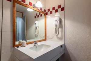 W łazience znajduje się umywalka i lustro. w obiekcie Les Résidences de Valmorel - maeva Home - 2 Pièces 5 personnes Selection 11 w mieście Valmorel