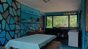 Cette chambre bleue comprend un lit et une fenêtre. dans l'établissement Piecefull bayview Cottage with Kitchen near Tofo, à Inhambane