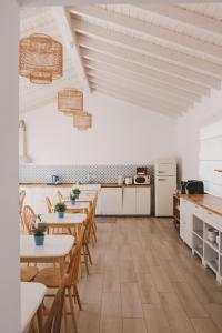 - une cuisine avec des tables et des chaises en bois dans la chambre dans l'établissement Pure Fonte Velha B&B, à Vila do Bispo