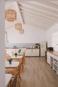 a kitchen with wooden tables and chairs in a room at Pure Fonte Velha B&B in Vila do Bispo +25 photos