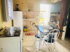 cocina con mesa, sillas y nevera en Tranquilidade na Chapad dos Veadeiros, en Cavalcante