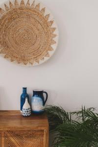a plate on a wall with two vases on a table at Pure Fonte Velha B&B in Vila do Bispo