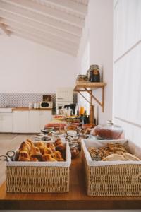 two baskets of pastries on a table in a kitchen at Pure Fonte Velha B&B in Vila do Bispo
