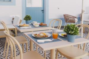 a table with plates of food and orange juice at Pure Fonte Velha B&B in Vila do Bispo