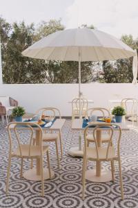 a table and chairs with an umbrella on a patio at Pure Fonte Velha B&B in Vila do Bispo