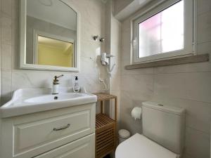 baño con lavabo y aseo y ventana en SK Lisboa Villa Guesthouse, en Lisboa