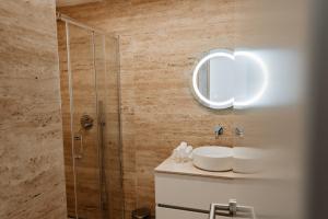 uma casa de banho com um chuveiro, um lavatório e um espelho. em A 0.4 - Alexa Smart House em Braga