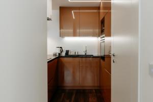 a kitchen with wooden cabinets and a sink at A 0.4 - Alexa Smart House in Braga +4 photos