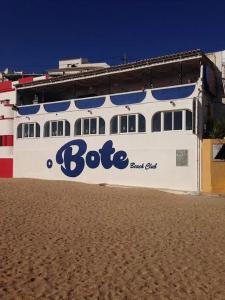 - un bateau sur la plage à côté d'un bâtiment dans l'établissement Apartamento encantador a 100m da praia, à Carvoeiro