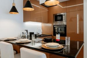 uma cozinha com uma mesa com pratos e copos de vinho em A 0.4 - Alexa Smart House em Braga