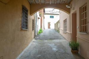 un callejón vacío con un arco entre dos edificios en Ferienwohnung Rosa in der Residenza dei Piaceri Perduti, en Lastra a Signa