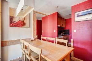 a dining room with a wooden table and chairs at Résidence Les Crêts - maeva Home - 3 Pièces 6 Personnes - Confort MAE-1026 in Les Allues