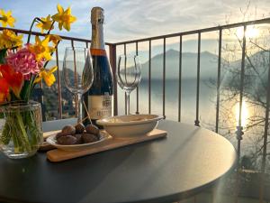 uma mesa com uma garrafa de vinho e dois copos em Bellevue Apartment: sunset on Lake Como em Bellano