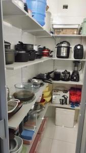 a kitchen with shelves filled with pots and pans at Casa com Piscina Aquecida Mongaguá in Mongaguá