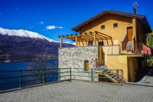 een huis met een balkon en een meer en bergen bij Bellevue Apartment: sunset on Lake Como in Bellano
