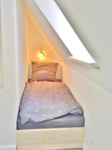 Una cama pequeña en una habitación bajo una escalera en Ferienhaus Wacken am Teich, en Wacken