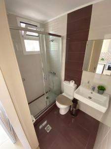 a bathroom with a toilet and a shower and a sink at Roula Kotsonis Superior Apartment in Argassi