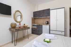 a small kitchen with a table and a mirror at Sunny Studios 2 in Mángana