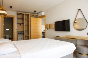 a bedroom with a bed and a desk and a television at Asterina Hotel in Turgutreis