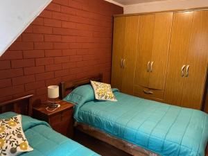 a bedroom with two twin beds and wooden cabinets at CASA AMOBLADA EN TALCA PARA 6 PERSONAS in Talca